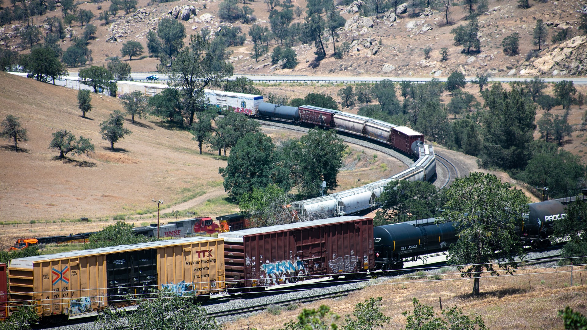 A freight train weaves trough a desert.