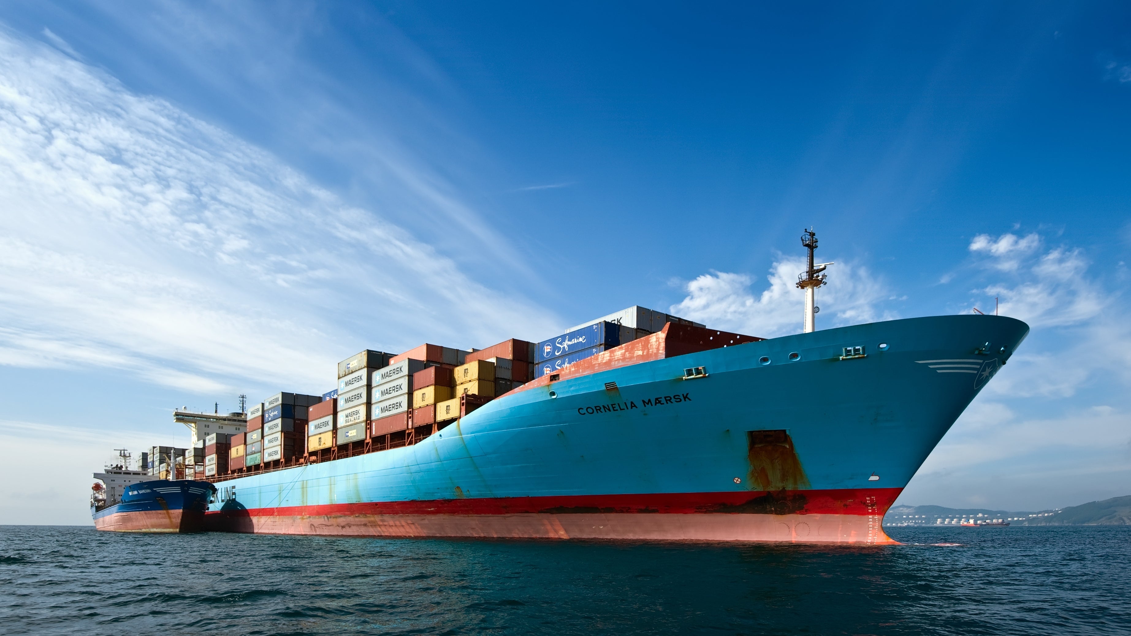 Container ship with a refueling tanker alongside it