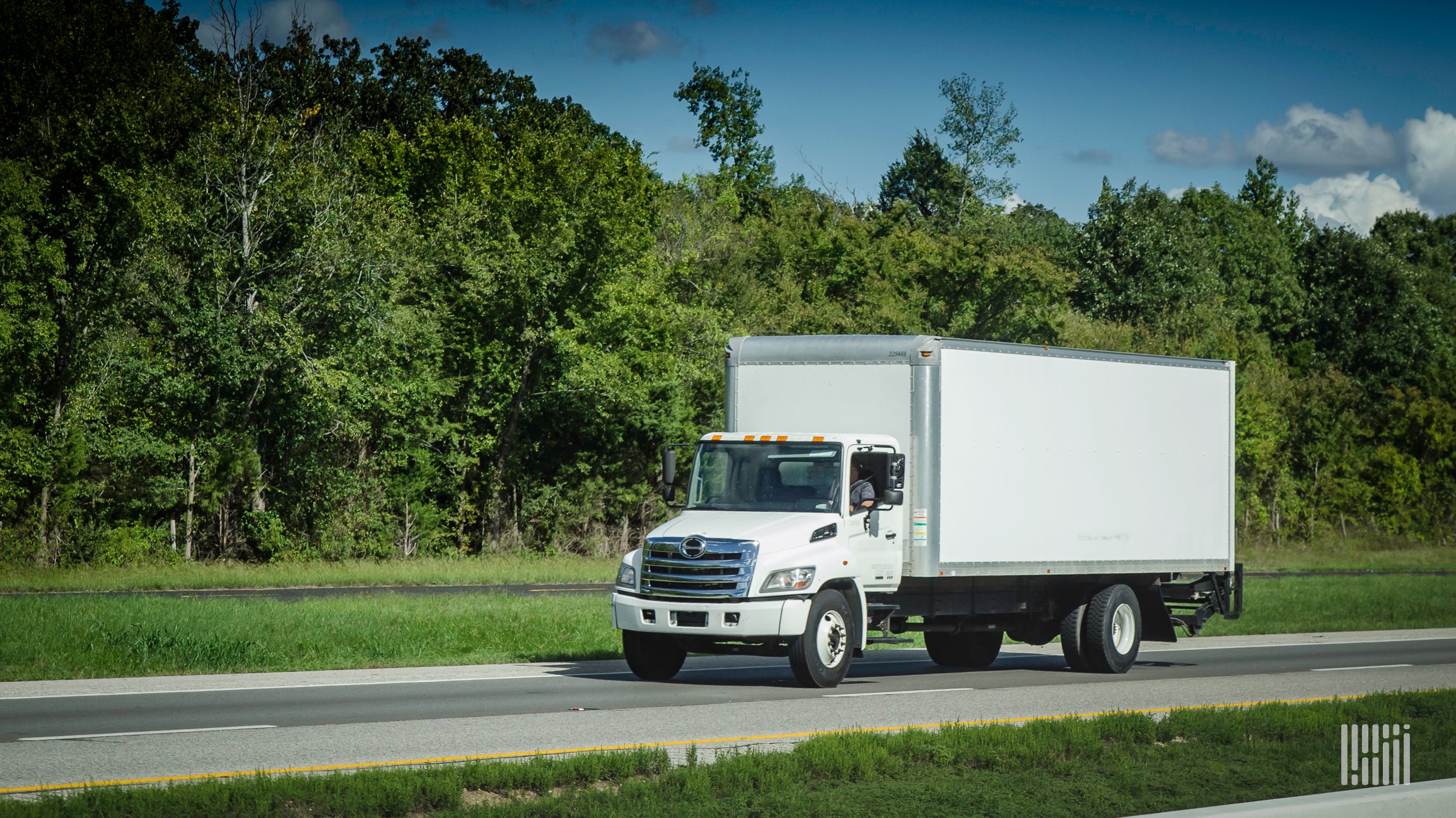 White box truck driving down the highway