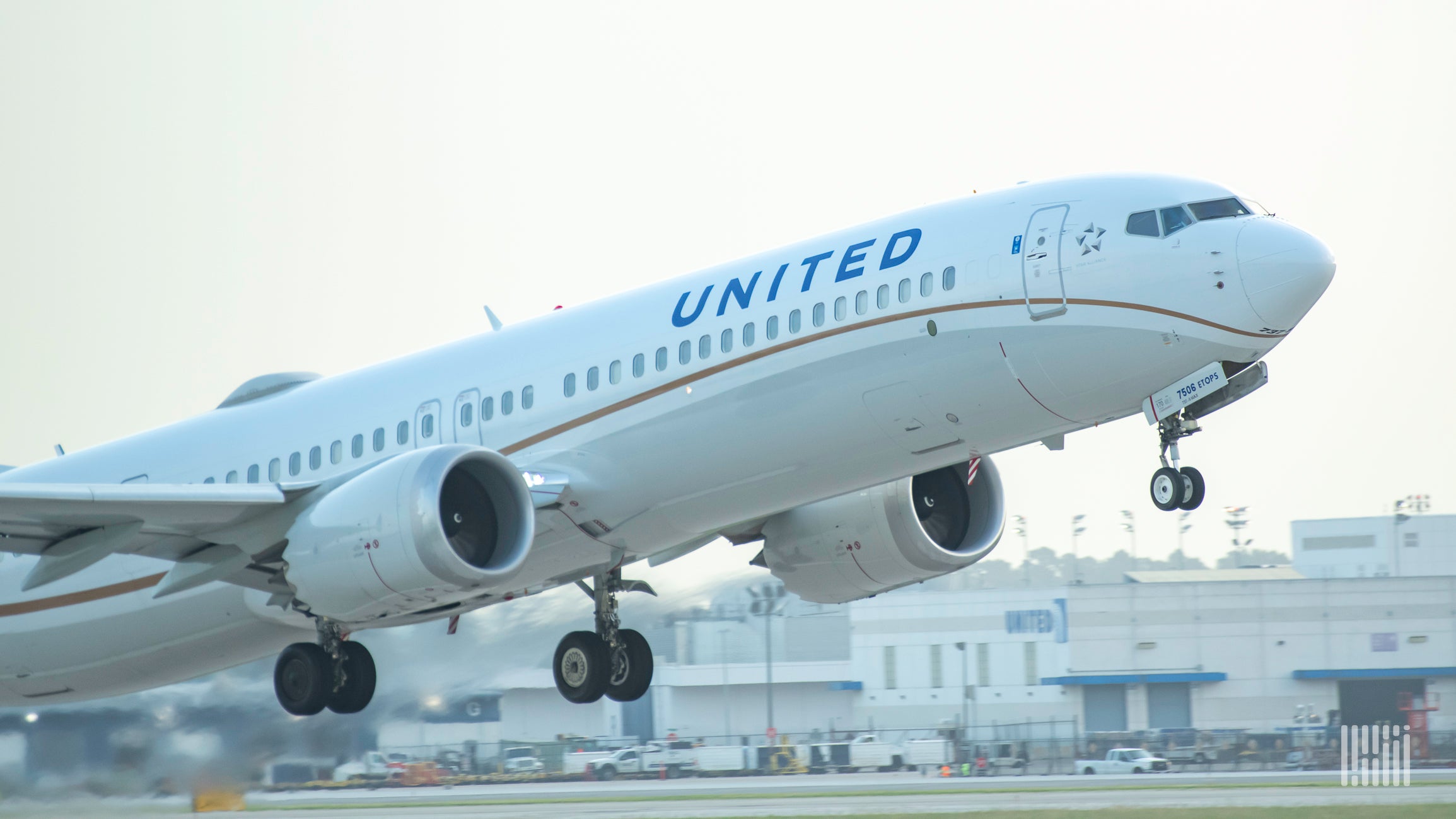 A close up of a white United Airlines jet taking off.