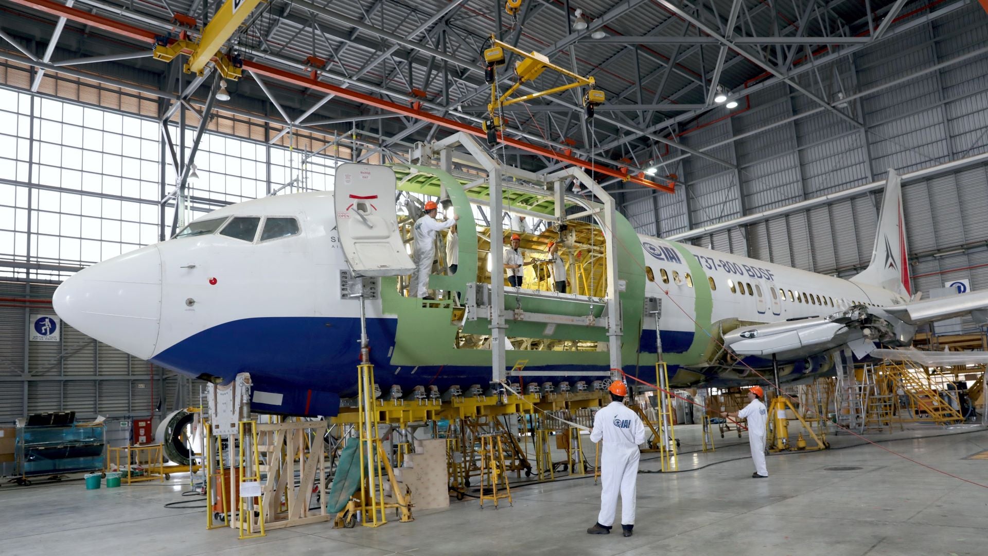 A Boeing 737-800 jet in a hanger on a stand getting an interior overhaul.