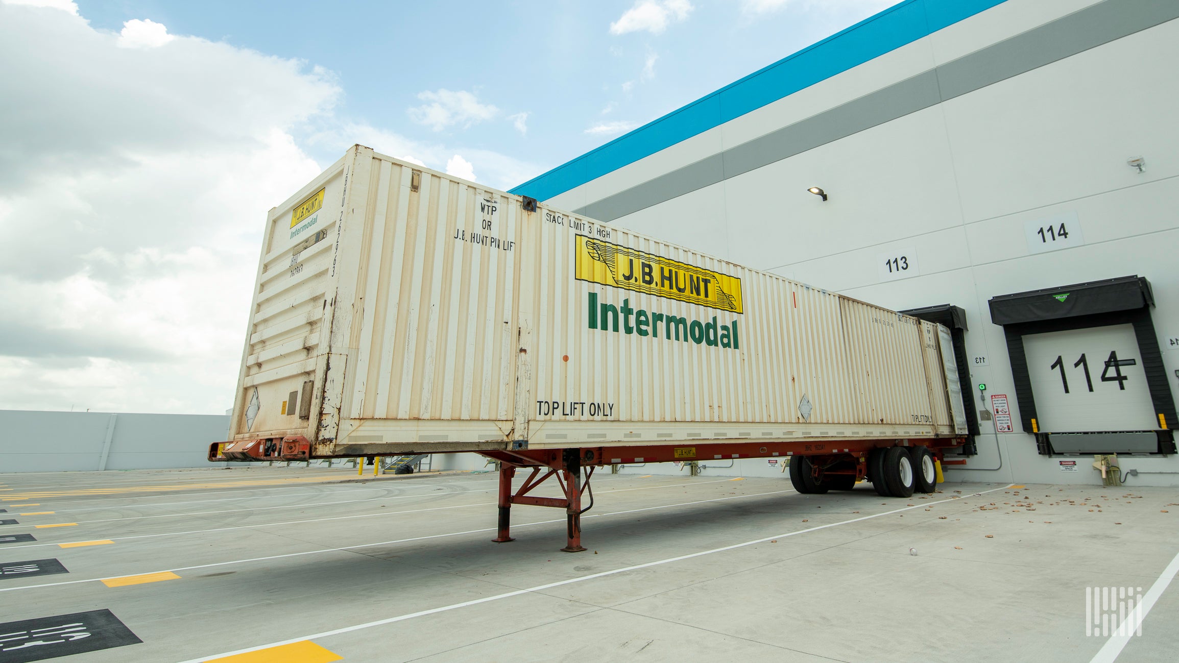 A J.B. Hunt intermodal trailer backed up to a warehouse door