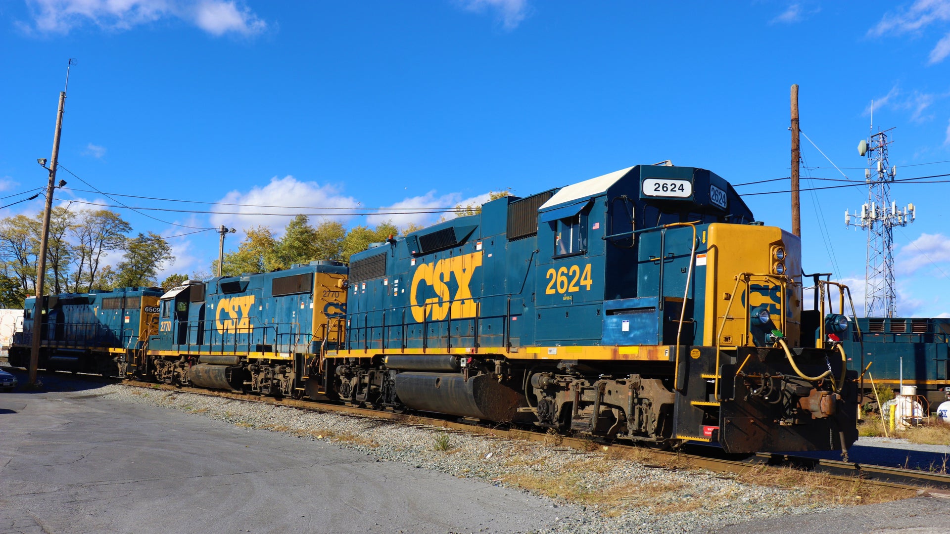 A CSX locomotive pulls railcars down a railroad track.