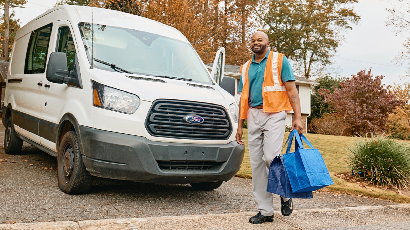 Man walking in front of van with 2 packages