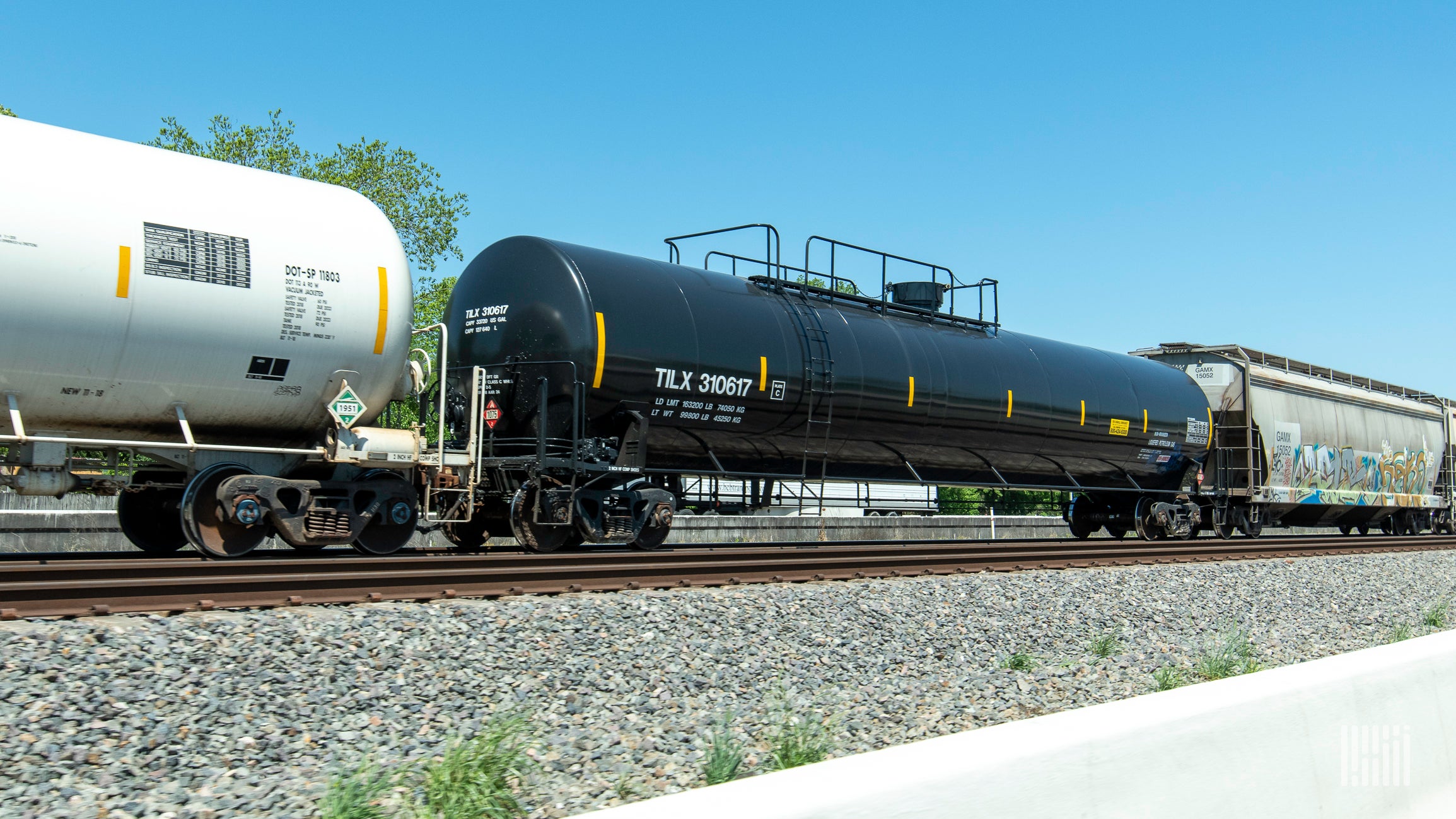 A tank car parked at a rail yard.