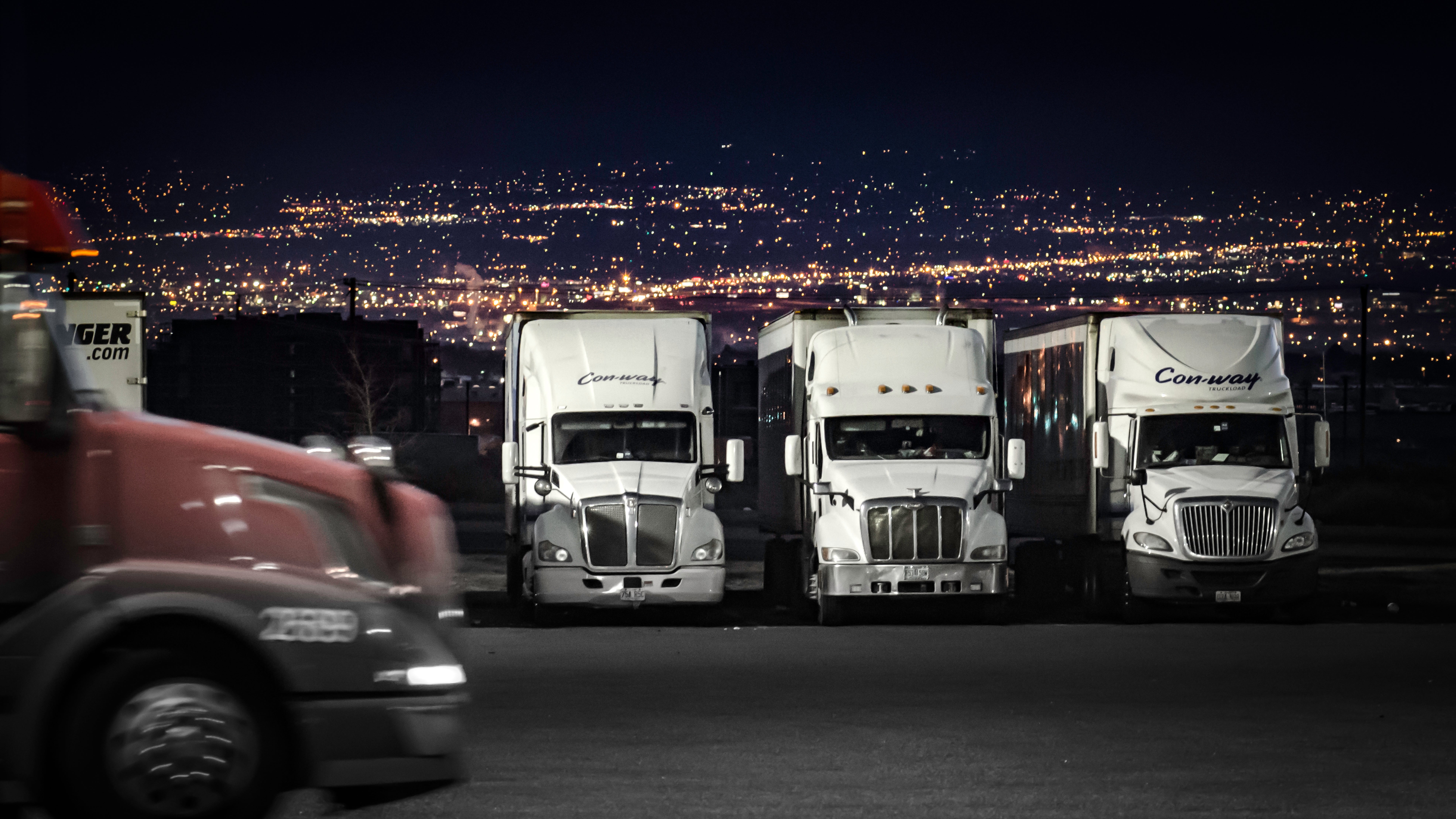 Trucks parked in parking lot at night.