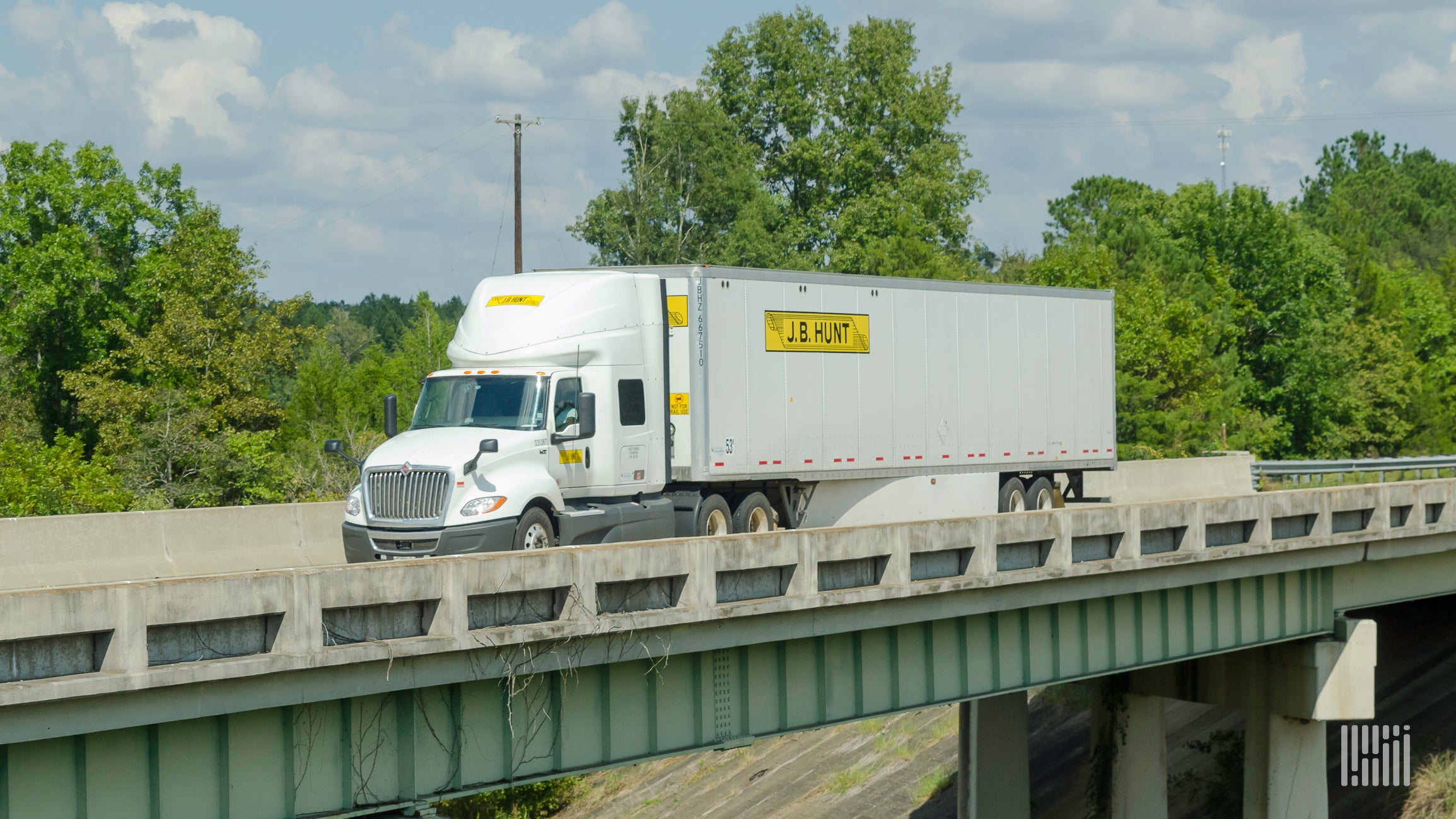 A J.B. Hunt tractor and trailer crossing a bridge