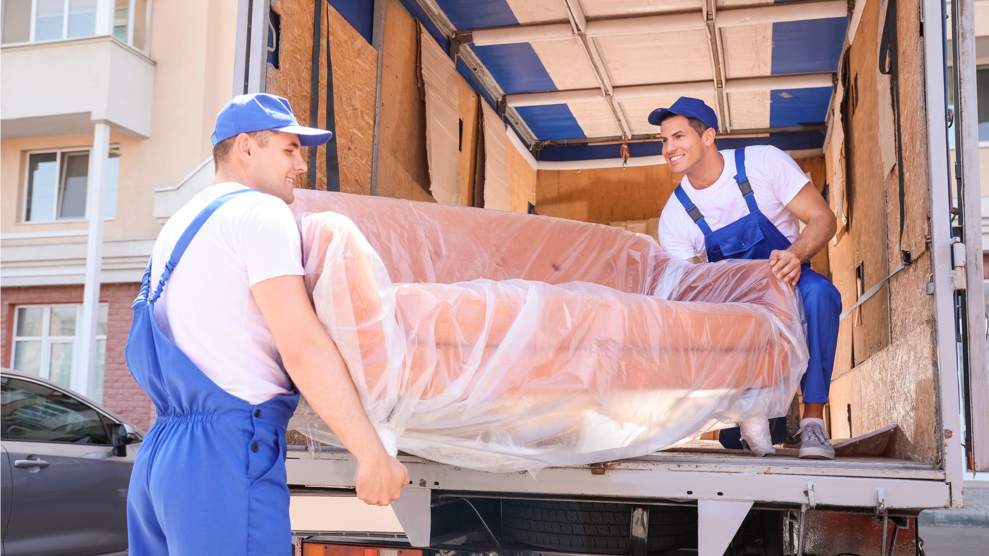 2 men unload couch from truck