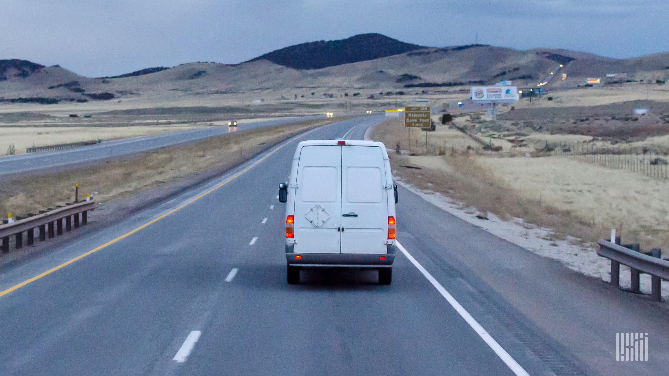 White delivery van driving on highway