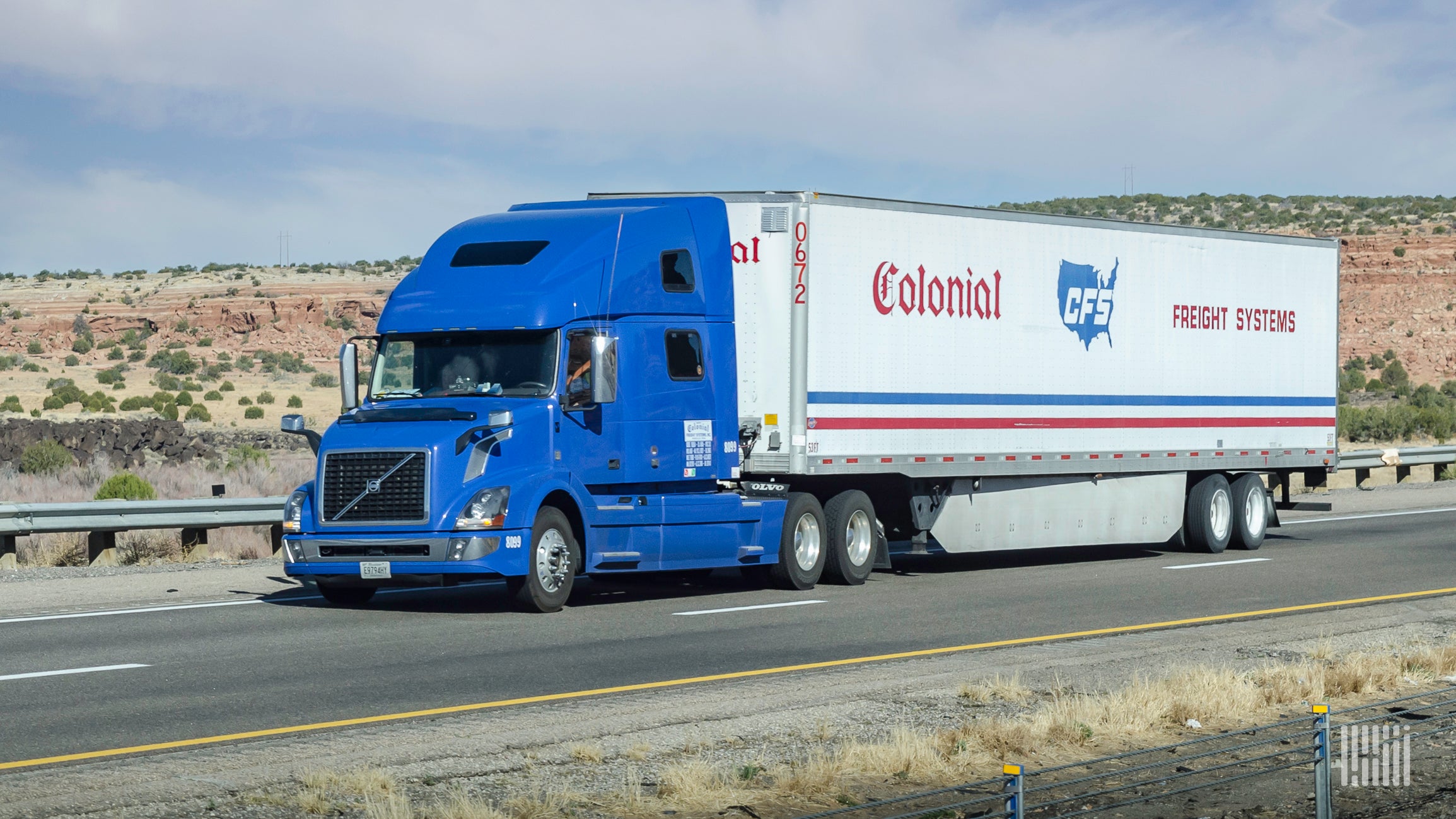 A blue tractor pulls a Colonial Freight Systems trailer