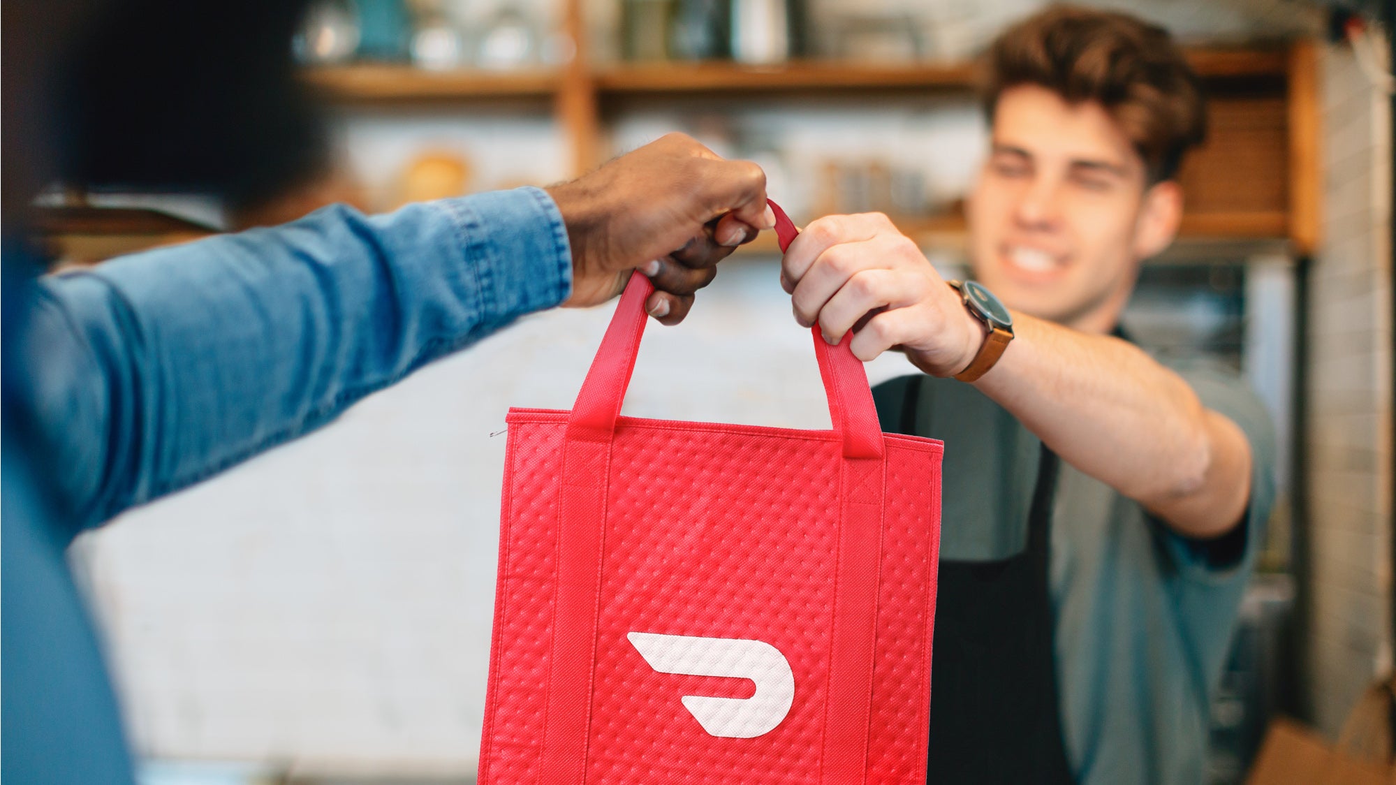 Man hands over DoorDash bag to driver