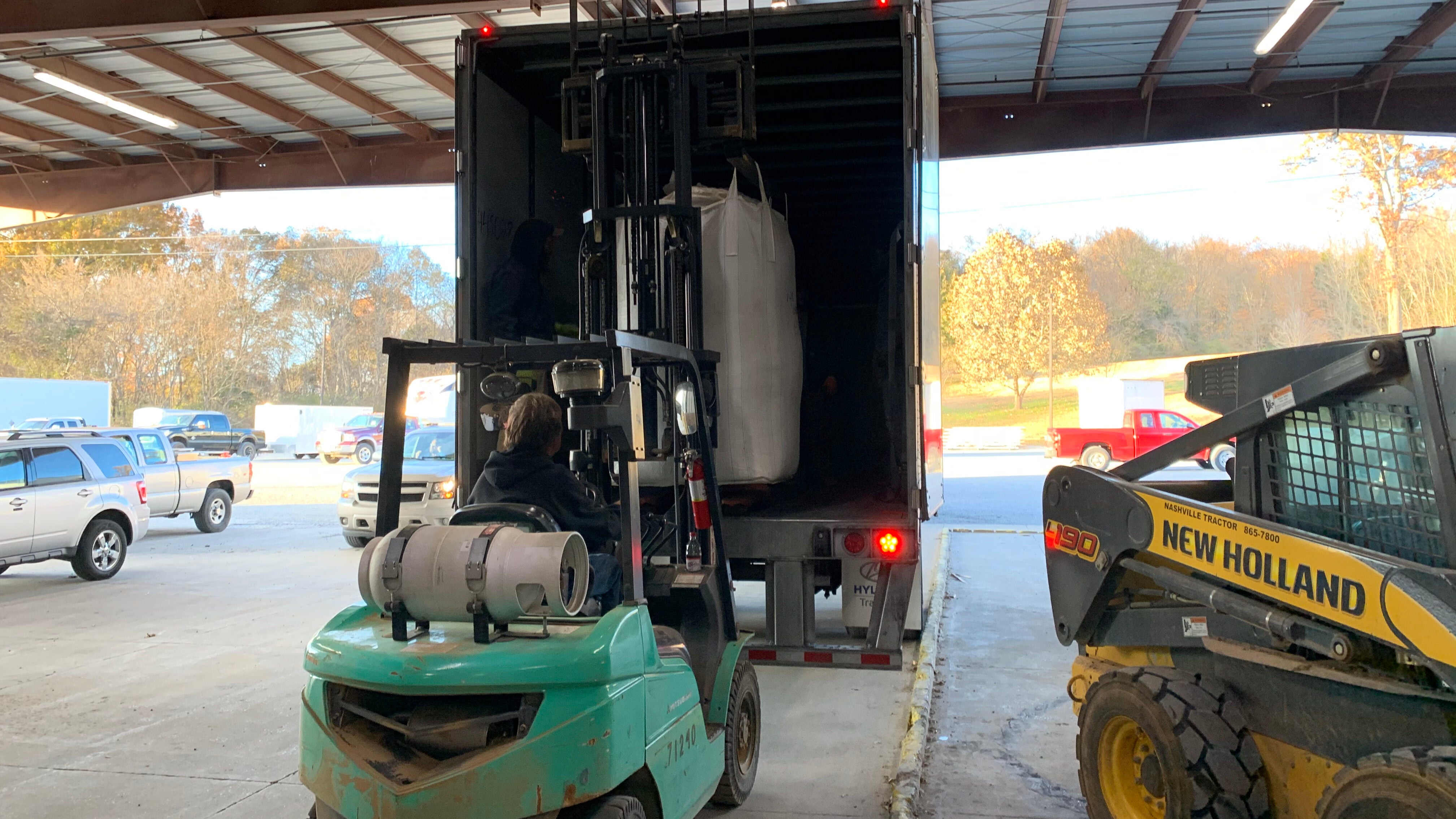 Forklift loading hemp into back of truck.