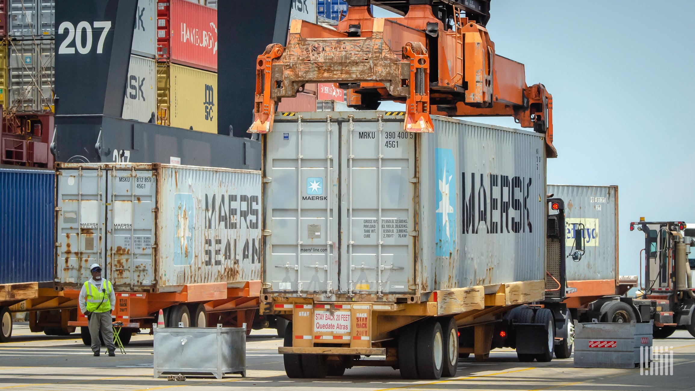 trucks with shipping containers wait at the Port of Houston