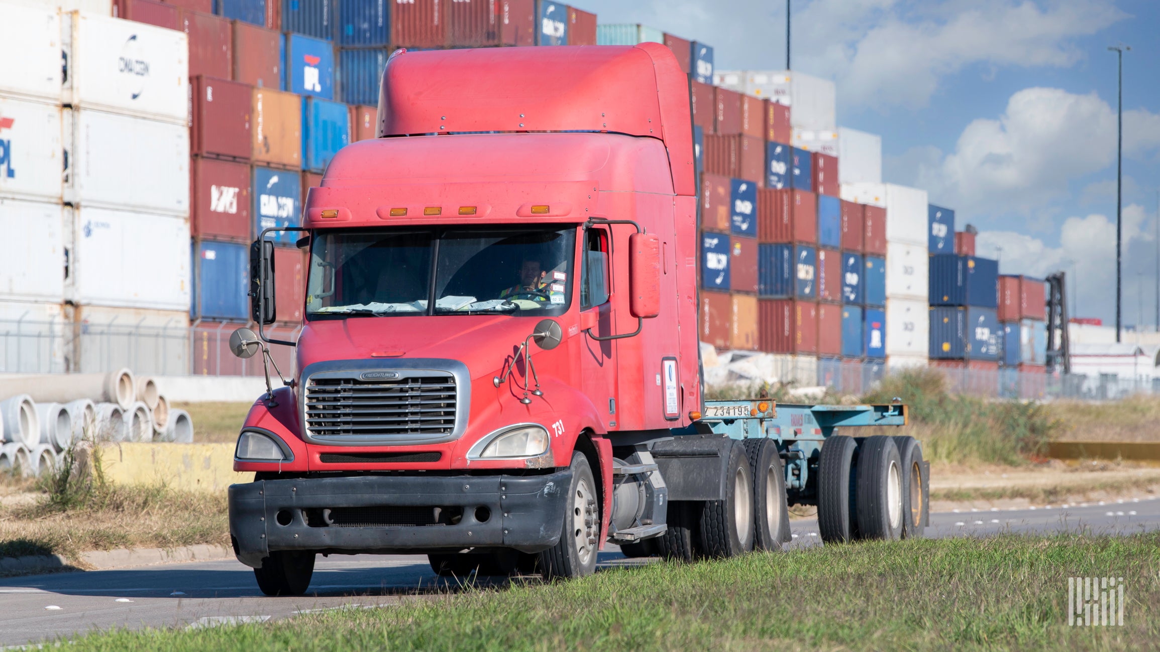 A red truck with chassis at port