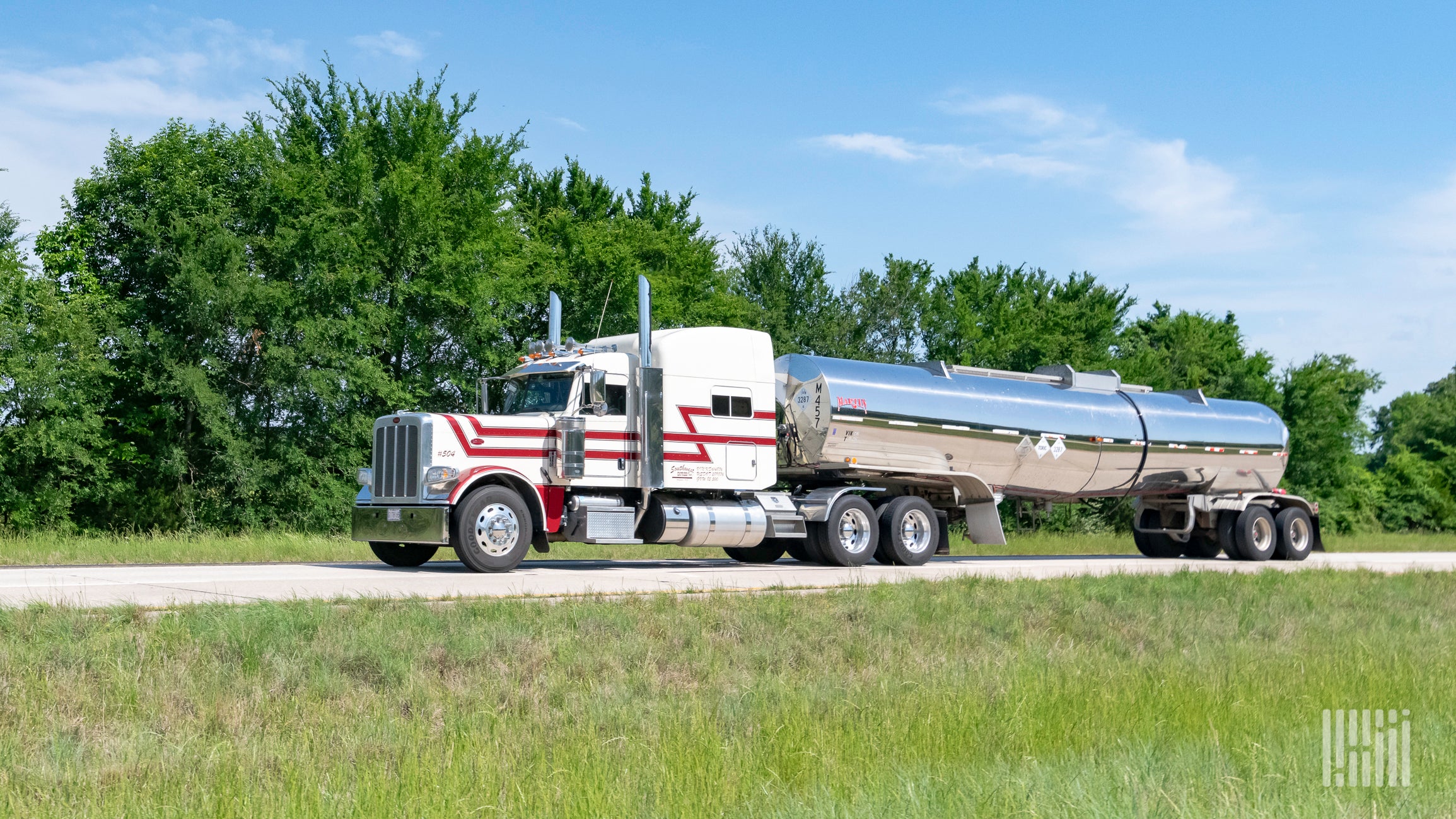 A truck hauling a tank trailer on the highway