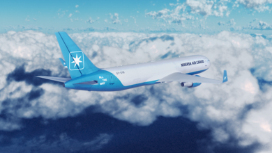 A white and powder blue Maersk Air Cargo jet flies above the clouds.