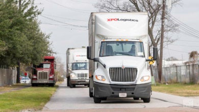 Two XPO trucks on the road