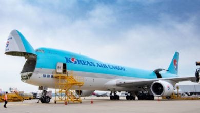 A baby-blue Korean Air freighter with the nose cone open for loading.