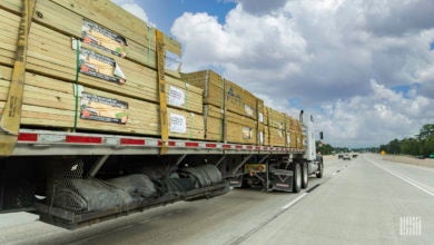 A flatbed rig moving lumber on the highway