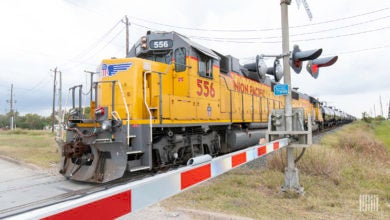 A freight train passes by a railroad crossing.