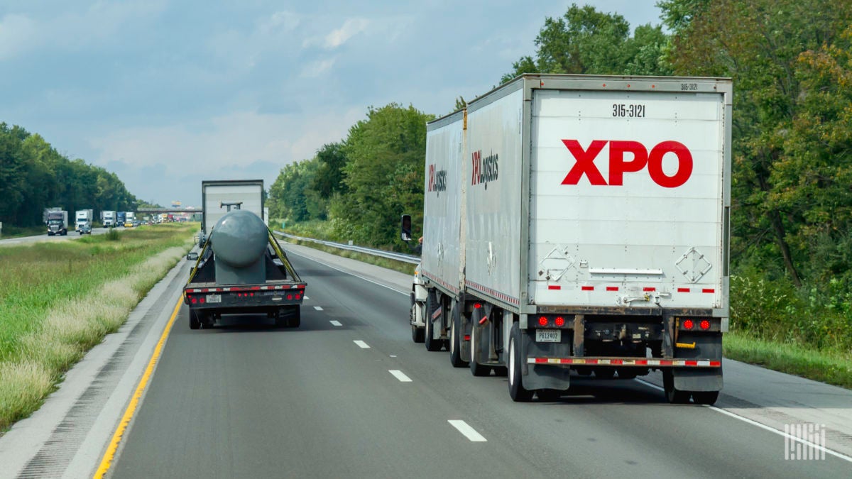 An XPO tractor pulling two LTL trailers on the highway