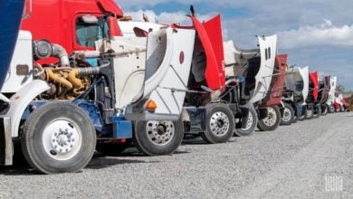 Row of used trucks with hoods open at Ritchie Brothers' auction