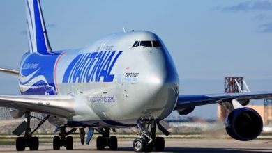 A silver-and-blue National Airlines jumbo jet. Close up front view.