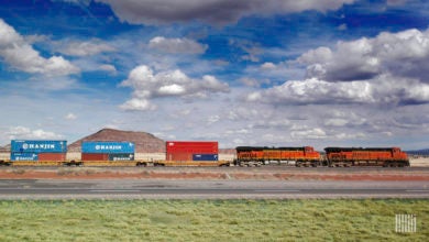 A BNSF train hauls intermodal containers across a grassy field.