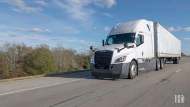 A white tractor-trailer on highway