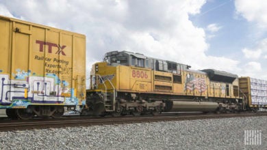 A Union Pacific locomotive in a yard next to two rail cars.