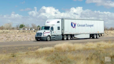 A white Covenant tractor-trailer on highway