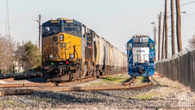 A CSX train hauling rail cars enters a rail yard.