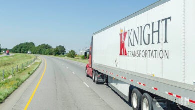 A red Knight tractor pulling a white Knight trailer