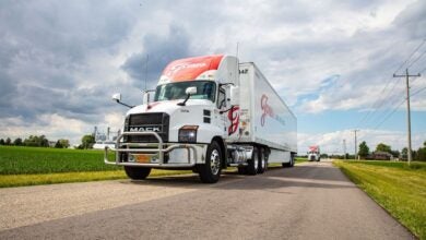 A white and red Jones Logistics tractor-trailer on a highway