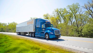 A blue Werner tractor on the highway pulling a trailer