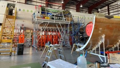 A fuselage of an aircraft on racks and stripped down in a hanger for airframe upgrades.