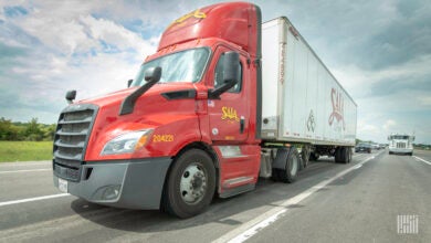 A red Saia truck pulling a white Saia trailer