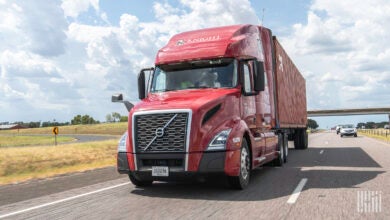 A red Knight tractor pulling a red intermodal container on highway