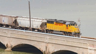 A train hauling railcars crosses a bridge.