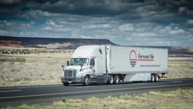 A white tractor pulling a Forward Air trailer