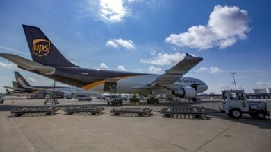 Brown-tail UPS freighters parked at an airport on a sunny day.