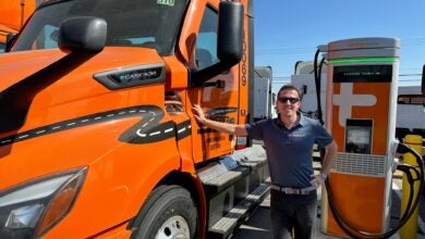 Orange Schneider truck and ChargePoint fast charger