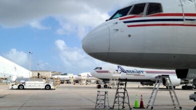 Close up from the side of the front nose of a large jet. Planes in the background say Amerijet on side.