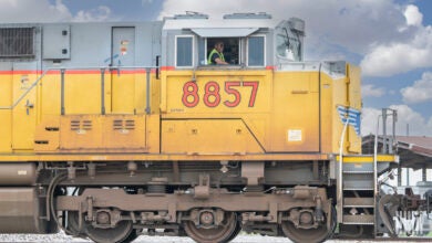 A man sits in the locomotive cab of a Union Pacific train.