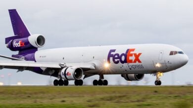 A purple-tail FedEx jet with three engines rolls on the runway.