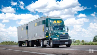 A green ABF Freight tractor pulling two LTL trailers