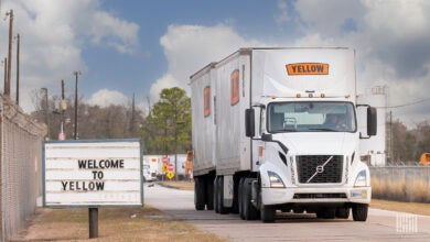 A Yellow tractor pulling two LTL trailers at a terminal in Houston