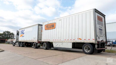 A Yellow tractor pulling two LTL trailers