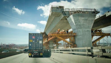 Truck on highway next to bridge construction