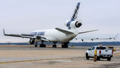 Rear view of a white cargo jet with blue Western Global lettering on the tarmac.